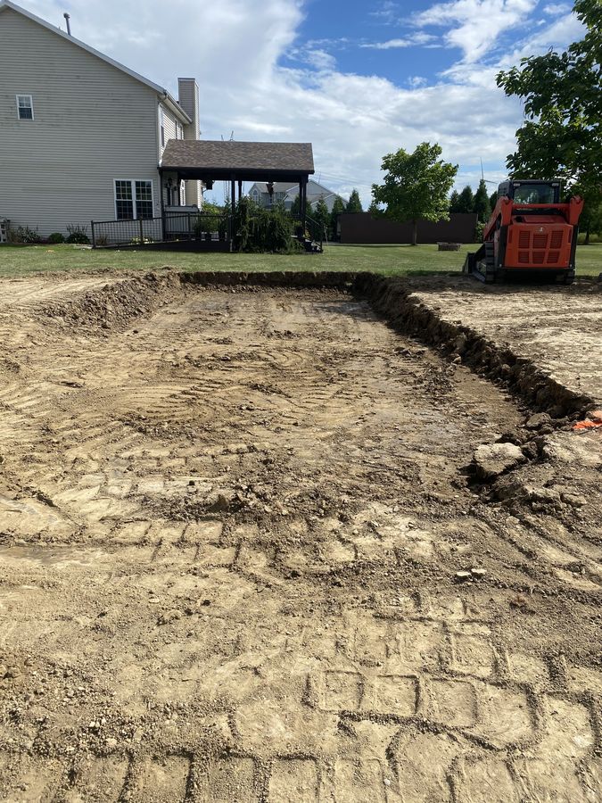 Excavated foundation trench with skid steer on site
